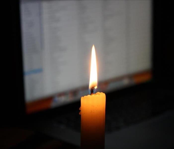 Candle flame in front of a computer.