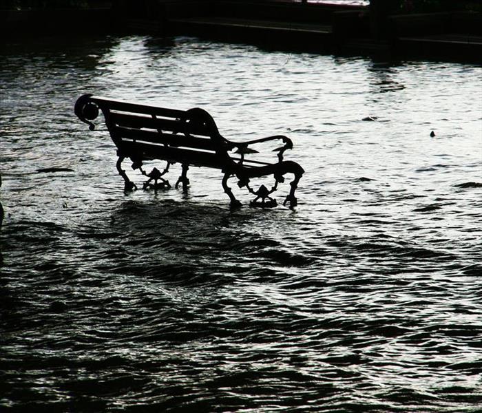 Park bench with water surrounding it.